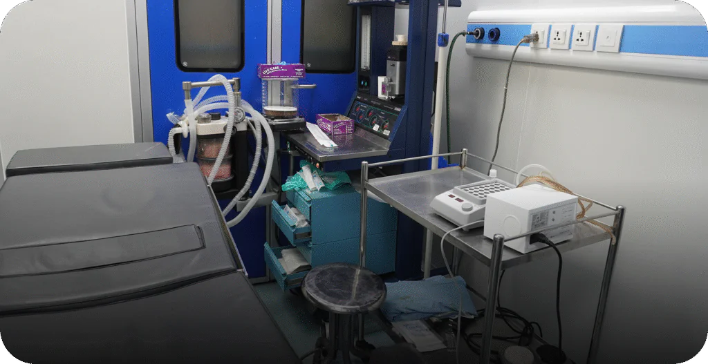 IVF procedure room with an adjustable examination table and anesthesia machine/medical delivery equipment. - AAS Fertility